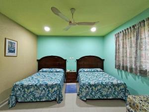 Un dormitorio con dos camas y un ventilador de techo. en Novotel De Poza Rica, en Poza Rica de Hidalgo