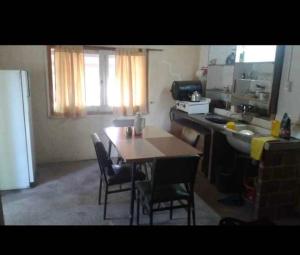 una cucina con tavolo e sedie e una cucina con lavandino di Rodolfo cabaña a Cosquín