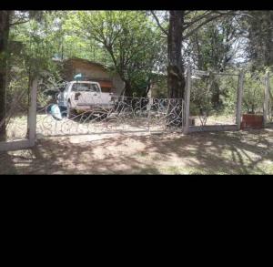 un cancello con un camion parcheggiato in un cortile di Rodolfo cabaña a Cosquín