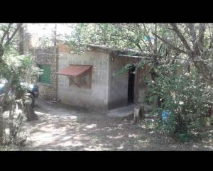 un piccolo edificio in mattoni con finestra e porta di Rodolfo cabaña a Cosquín