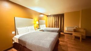 a hotel room with two beds and a chair at Redondo Beach Inn-LAX in Gardena