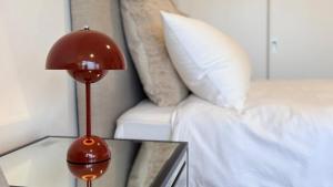 a red lamp on a glass table next to a bed at Stunning Harbour Bridge Views Apartment in Sydney