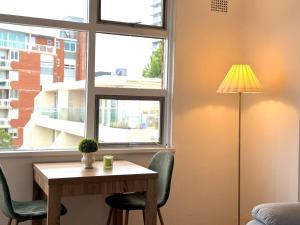 a table and chairs in a room with a window at Stunning Harbour Bridge Views Apartment in Sydney