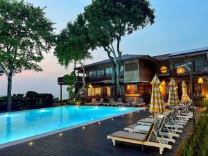 een zwembad met ligstoelen naast een gebouw bij Birds and Bees Resort in Pattaya South