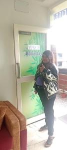 una mujer está parada frente a una tienda en Yuvati Homestay, en Bumlitan