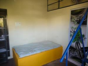 Un dormitorio pequeño con una cama amarilla y una escalera azul. en MITHRA SINGLE room, en Khammam