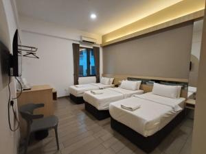 a hotel room with three beds and a desk at Hotel Golden View Nilai in Nilai +58 photos