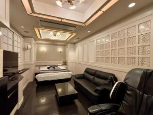 a salon room with a couch and a chair at Hotel PRINCESS2 -大人専用- in Tokyo