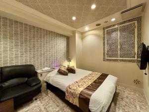 a bedroom with a bed and a chair and a window at Hotel PRINCESS2 -大人専用- in Tokyo