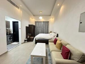 a living room with a couch and a bed at Entire Studio Apartment Beside Oasis towers in Ajman 
