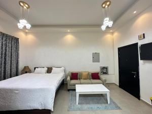 a bedroom with a large bed and a couch at Entire Studio Apartment Beside Oasis towers in Ajman  +13 photos