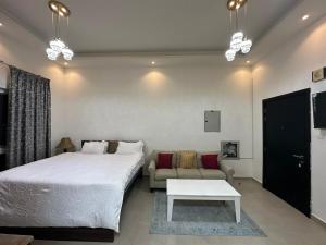 Un dormitorio con una cama grande y un sofá. en Entire Studio Apartment Beside Oasis towers, en Ajman