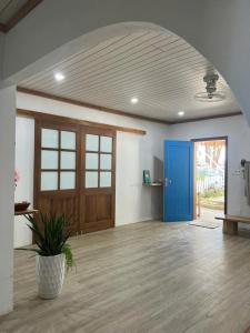 an empty room with a blue door and a potted plant at Lalagigi Homestay in La Gi