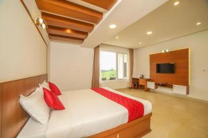 a bedroom with a bed with red pillows and a television at Heavenly Hills 4 BHK Villa - 1 Bedroom in Kotagiri