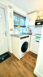 a kitchen with a sink and a dishwasher at Kaira's Nook in Wolverton +14 photos