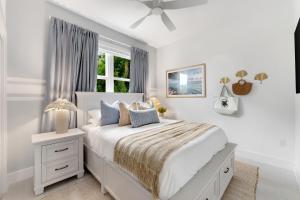 ein weißes Schlafzimmer mit einem Bett und einem Fenster in der Unterkunft Oceanfront Luxury w/Speakeasy Lounge, Dock & Pool in Islamorada + 40 Fotos