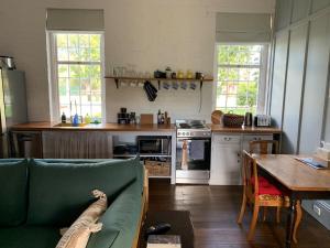 a kitchen with a couch and a table in a room at The Ol' Sunday School in Ross