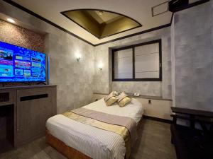 a bedroom with a bed and a flat screen tv at Hotel Crystal -大人専用-- in Tokyo +7 photos