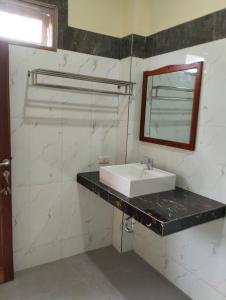 a bathroom with a white sink and a mirror at SADAMA Cottage in Tuk Tuk