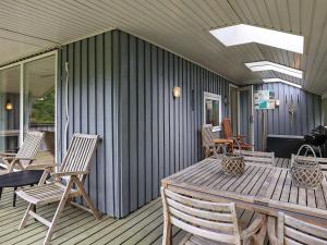 Ålbækにある5 person holiday home in Ålbæk-By Traumのポーチ(木製テーブル、椅子付)