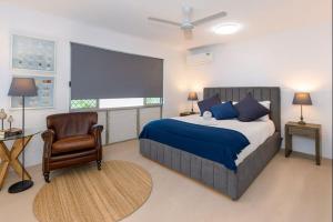a bedroom with a bed and a chair and a window at 2-Bedroom Charm near Mater Hospital Pimlico Townsville in Aitkenvale
