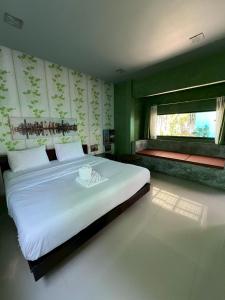 een slaapkamer met een groot wit bed en een raam bij ยูสีเกด รีสอร์ท in Si Sa Ket