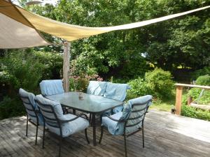 een tafel en stoelen op een houten terras bij Dragon's den main house in Takaka +5 foto's