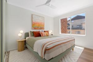 a bedroom with a bed and a window at Spacious Apartment Near Cronulla Beach in Cronulla