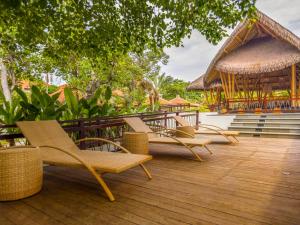 eine Terrasse mit Stühlen und einem Pavillon in der Unterkunft eL Hotel & Resort Bali Sanur in Sanur