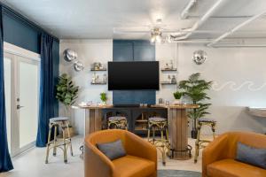 ein Wohnzimmer mit Fernseher und Tisch und Stühlen in der Unterkunft Oceanfront Luxury w/Speakeasy Lounge, Dock & Pool in Islamorada