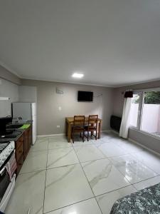 een keuken en eetkamer met een tafel en stoelen bij Líbano flat in El Bolsón