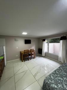 een slaapkamer met een bed, een tafel en een bureau bij Líbano flat in El Bolsón