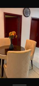 uma mesa e cadeiras com um vaso de flores em Cavalli apartment em Hausa
