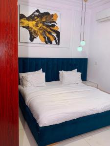uma cama com uma cabeceira azul num quarto em Cavalli apartment em Hausa