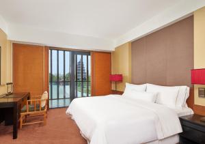a bedroom with a large white bed and a desk at The Westin Xi'an in Xi'an