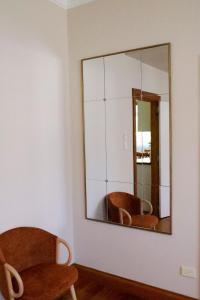 ein Spiegel an einer Wand in einem Zimmer mit zwei Stühlen in der Unterkunft Spacious 3-Bed Home in Central Tenterfield in Tenterfield + 17 Fotos