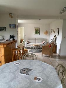a kitchen and a living room with a table and chairs at Chez Laurette et Louis in Ugine
