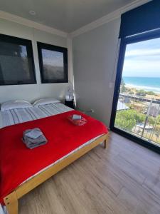 1 dormitorio con 1 cama con manta roja y ventana grande en Gore Bay View, en Gore Bay