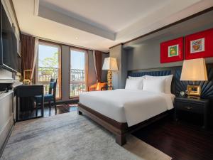 a hotel room with a bed and a desk and a television at Hanoi Solis Hotel in Hanoi