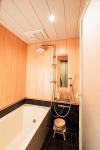 La salle de bains est pourvue d'une baignoire et d'un tabouret. dans l'établissement Machiya Izumi higashiyama, à Kyoto