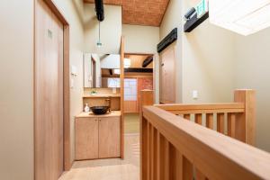 un couloir avec un escalier menant à une cuisine avec des placards en bois dans l'établissement Machiya Izumi higashiyama, à Kyoto 6 autres photos