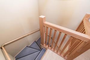 un escalier en bois avec des marches bleues et une rampe en bois dans l'établissement Machiya Izumi higashiyama, à Kyoto
