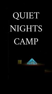 Un cartel que dice noches tranquilas, acampar con tienda de campaña. en Quiet Nights Camp, en Badīyah