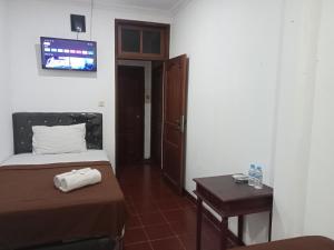 a small bedroom with a bed and a table at Pakemsari Resort Hotel in Pakem +32 photos