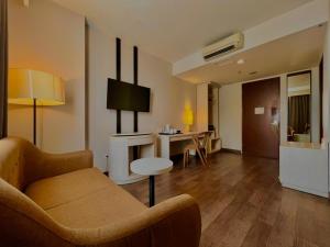 una sala de estar con un sofá y una mesa en Amandaru Hotel Pekalongan, en Pekalongan