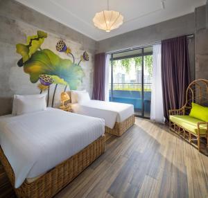 a hotel room with two beds and a chair at MissBamboo Hotel Nha Trang in Nha Trang