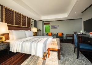 a hotel room with a bed and a desk and chairs at Hanoi Solis Hotel in Hanoi +87 photos