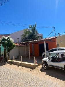 a white car parked in front of a house at Pé na festa in Aracati