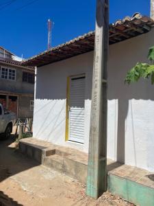 a small white house with a yellow door at Pé na festa in Aracati