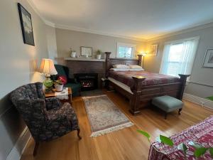 a bedroom with a bed and a chair and a couch at Plum Duff House in Tacoma
